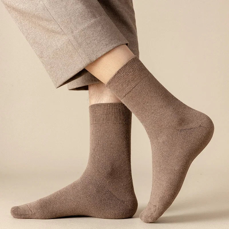 Brown socks worn with beige pants on a neutral background