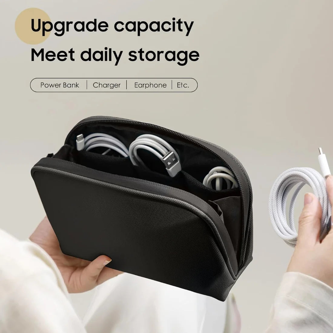 Black organizer pouch open with example cables arranged in separate inner pockets.