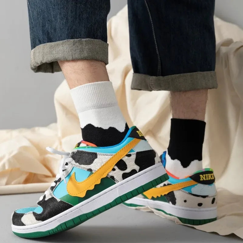 Colorful Nike sneakers with a cow pattern worn indoors.