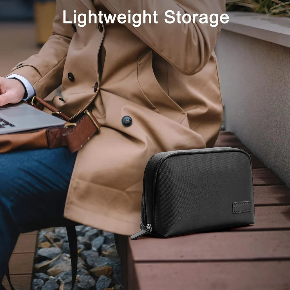 Black travel organizer pouch beside a seated person wearing a tan coat.