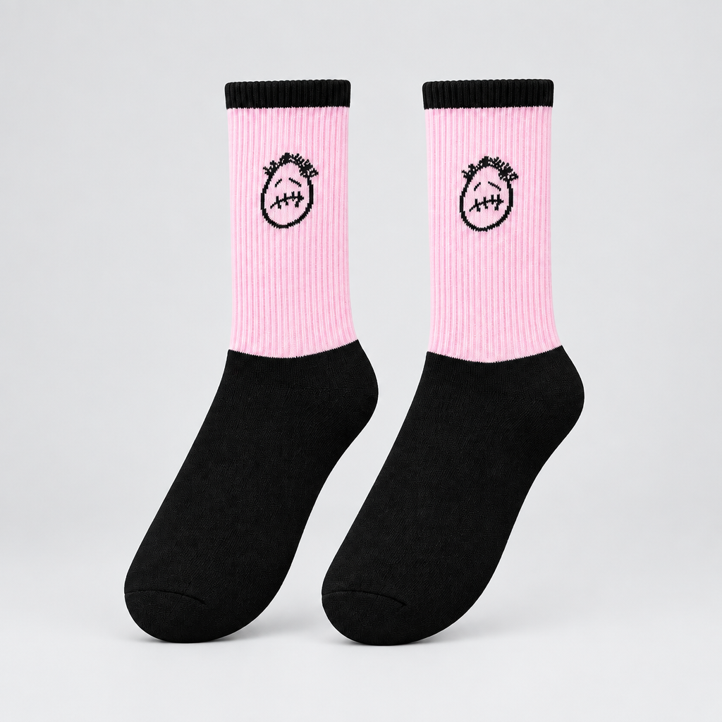 Pink and black crew socks with black stitched-face graphics and black cuffs, angled view