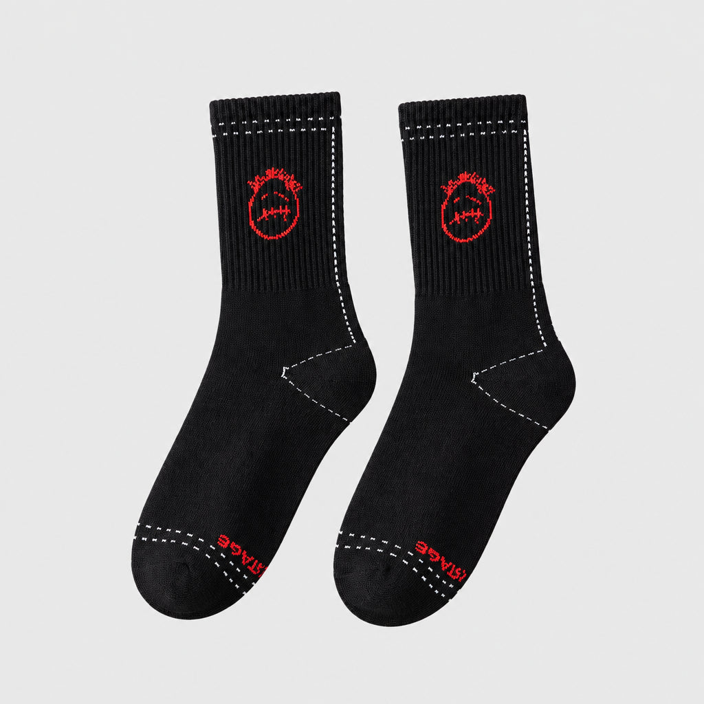 Black crew socks with red stitched-face graphics and white dashed outlines, angled view