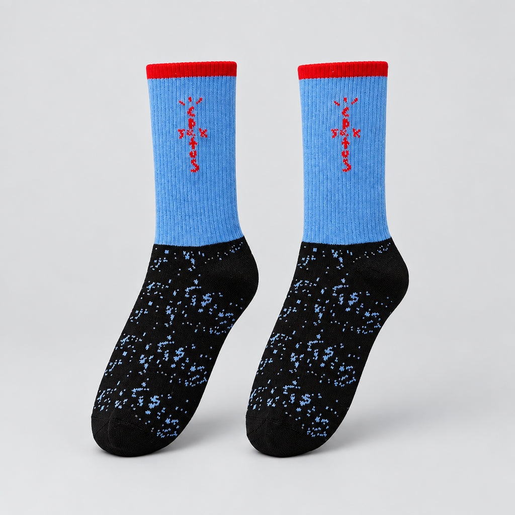 Blue and black crew socks with red cuffs, red cross-shaped lettering, and speckled feet, angled view