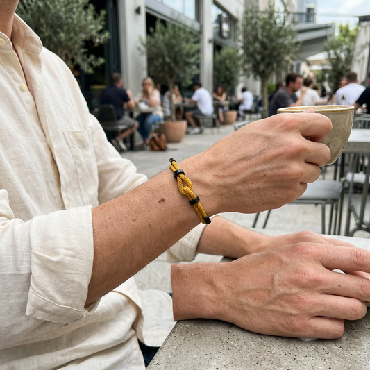 Pulsera amarilla con nudo central durante un café