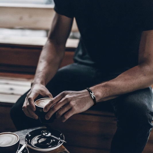 Pulsera negra fina sosteniendo una taza de café