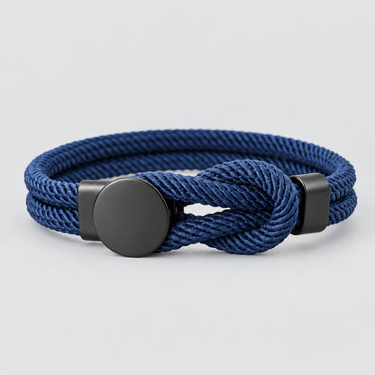 A red bracelet with a knot design and a black fastening mechanism, presented against a white background.