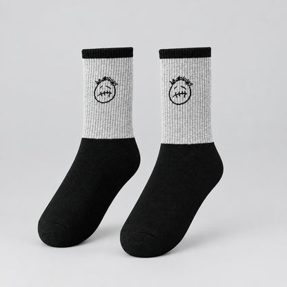 Gray and black crew socks with black stitched-face graphics and black cuffs, angled view
