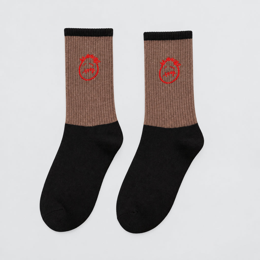Brown and black crew socks with red stitched-face graphics and black cuffs, angled view