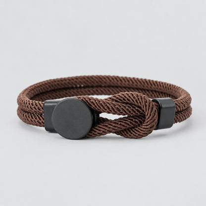 Brown braided bracelet with metal clasp on a white background