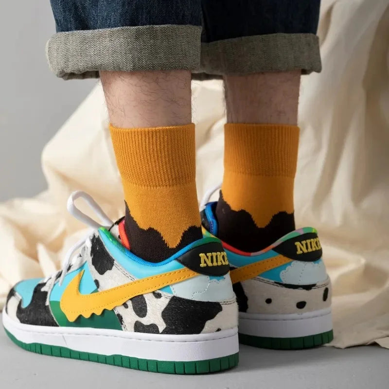 Colorful Nike sneakers with a cow print and patterned socks worn indoors.