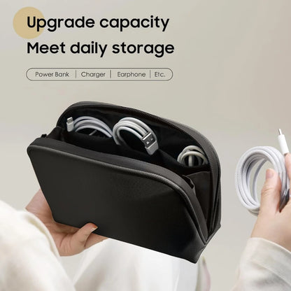 Black organizer pouch open with example cables arranged in separate inner pockets.