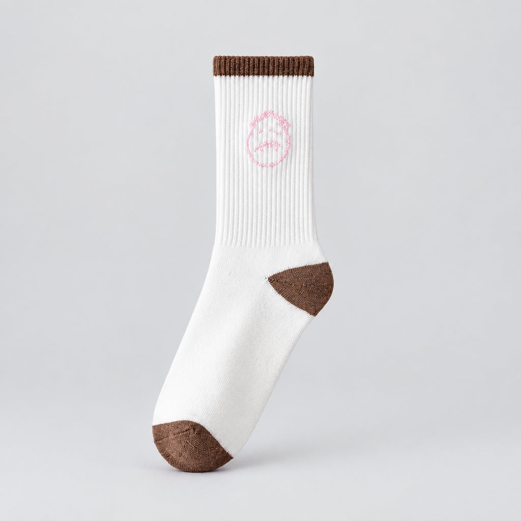 White crew sock with a pale pink stitched-face graphic and brown cuff, heel, and toe, angled view