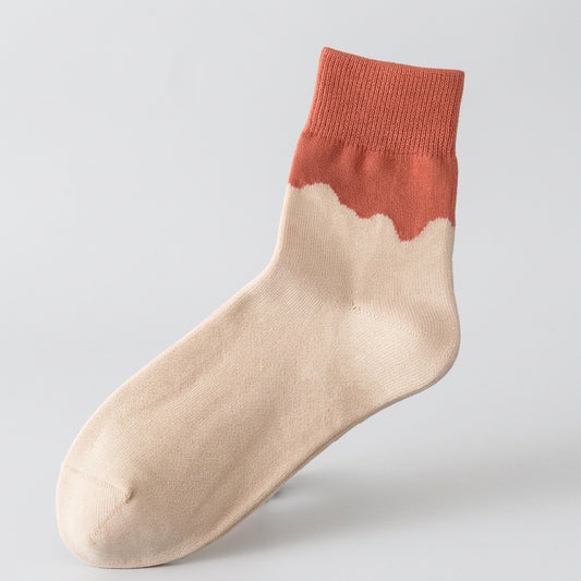 Beige sock with terracotta-colored top on a light gray background