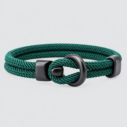 Teal braided bracelet with a gray metal clasp on a white background