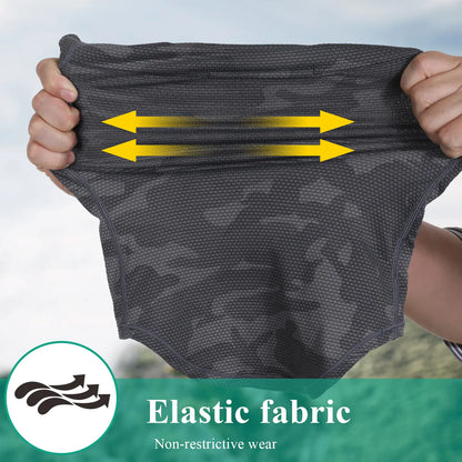 Person holding up gray fabric with yellow arrows indicating elasticity, on a blurred natural background.