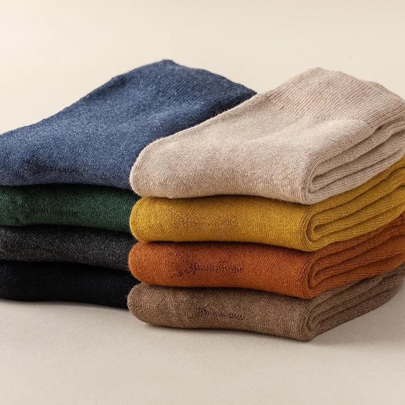 Stack of folded socks in various colors on a neutral background