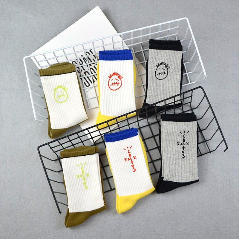 Folded graphic socks in wire baskets with olive, yellow and black feet and contrasting cuffs.