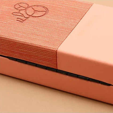 Close-up of a peach-colored fabric with a subtle pattern on a beige background
