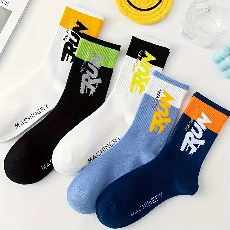 Four pairs of colorful socks with text on a white surface