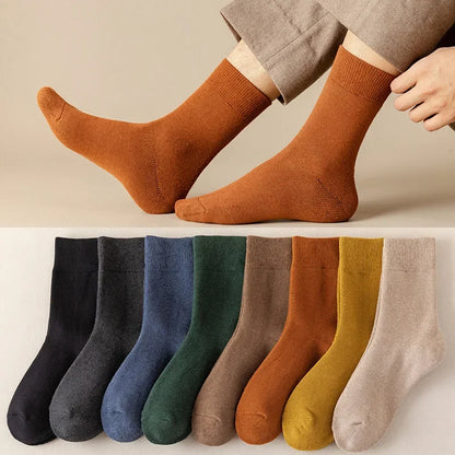 Brown socks worn by a person with a row of various colored socks below on a neutral background