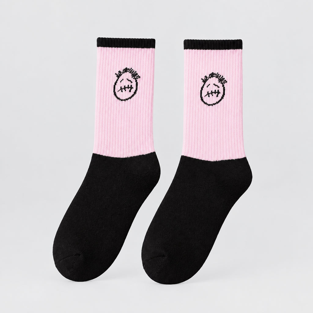 Pink and black crew socks with black cuffs and stitched-face graphics, angled view