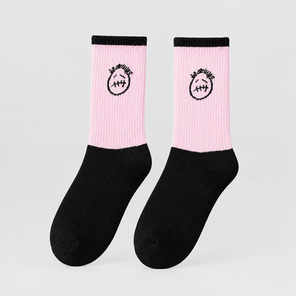 Pink and black crew socks with black cuffs and stitched-face graphics, angled view