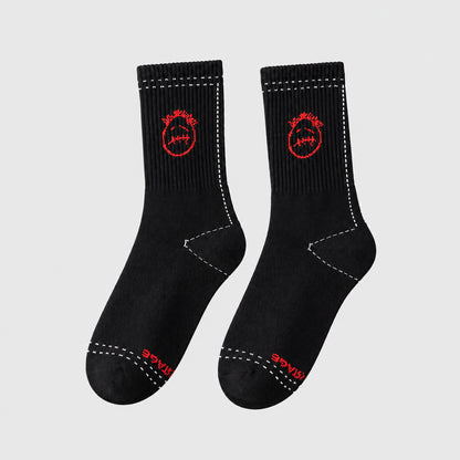 Black crew socks with red stitched-face graphics and white dashed outlines, angled view