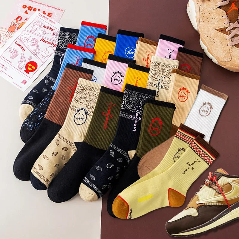 Assorted graphic socks in black, cream, blue, pink, brown, olive and yellow with paisley, face and lettering designs.