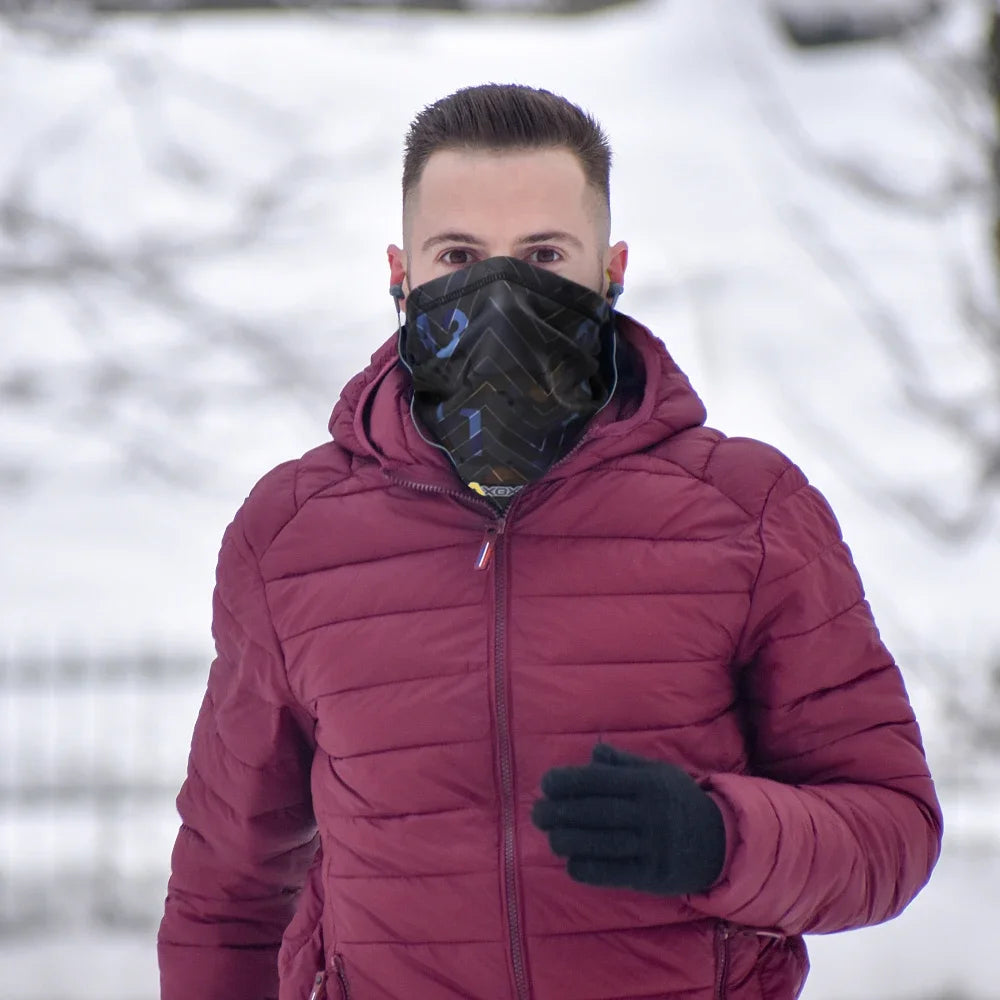 Person wearing a maroon puffer jacket and black gloves in a snowy landscape