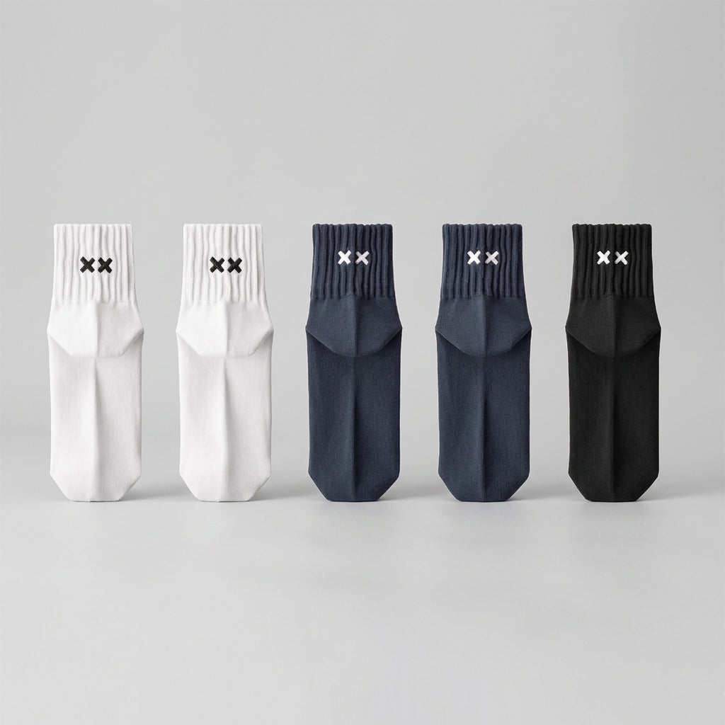 Set of five socks in white, gray, and black on a light gray background