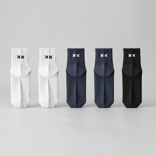 Set of five socks in white, gray, and black on a light gray background
