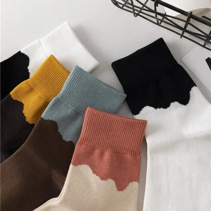Colorful socks with gradient patterns on a white surface.