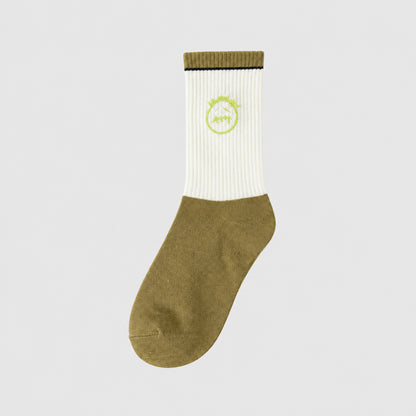 White and olive crew sock with a lime green stitched-face graphic and an olive cuff, angled view