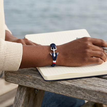Pulsera de ancla azul marino en una escena costera