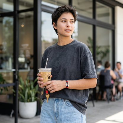 Pulsera negra con detalles rojos en un look juvenil de café