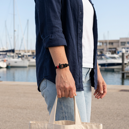 Pulsera negra con grillete en un look casual náutico